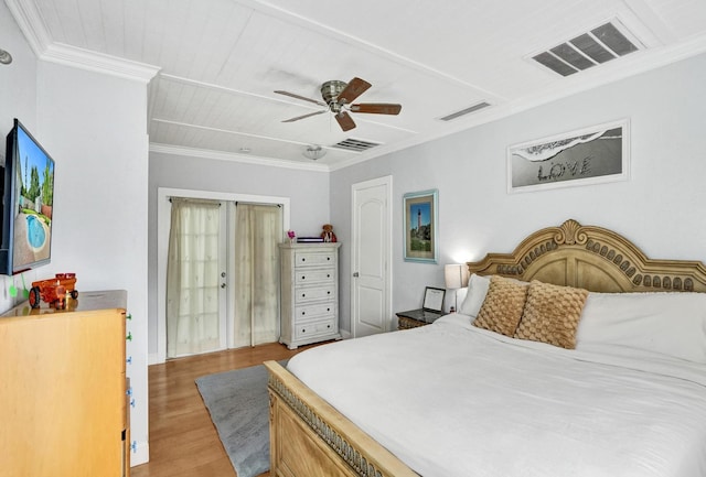 bedroom with wood finished floors, ornamental molding, and a ceiling fan