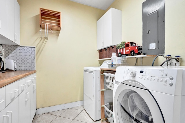 clothes washing area with cabinets, light tile patterned floors, electric panel, and washing machine and clothes dryer