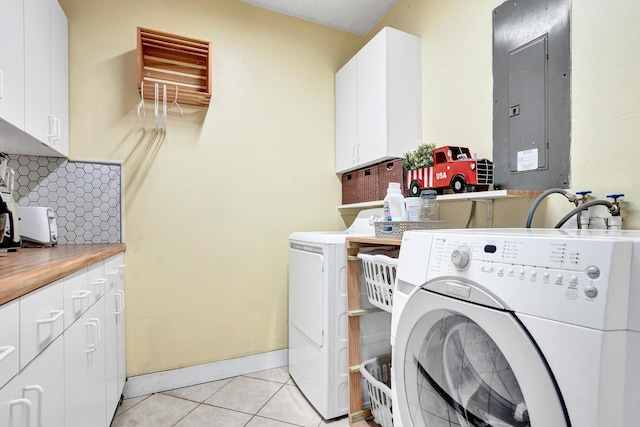 laundry room with electric panel, washer and clothes dryer, light tile patterned floors, and cabinet space