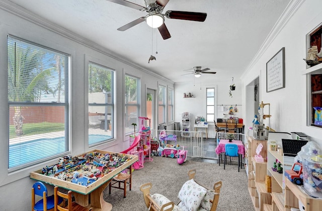 game room with carpet, a textured ceiling, plenty of natural light, and ornamental molding