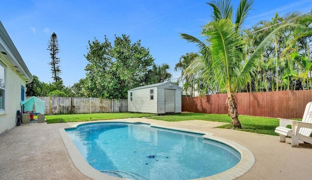 view of swimming pool featuring a lawn, a patio area, and a storage unit