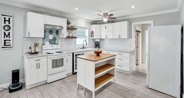 kitchen with sink, white cabinets, white appliances, and ventilation hood