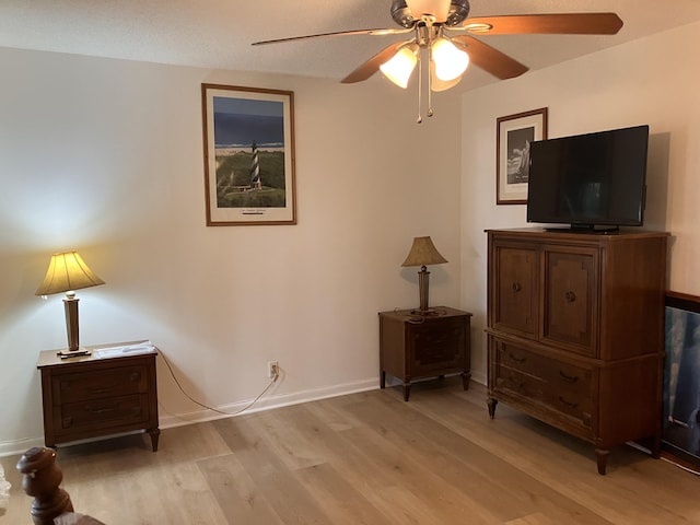 sitting room with ceiling fan, a textured ceiling, and light wood-type flooring