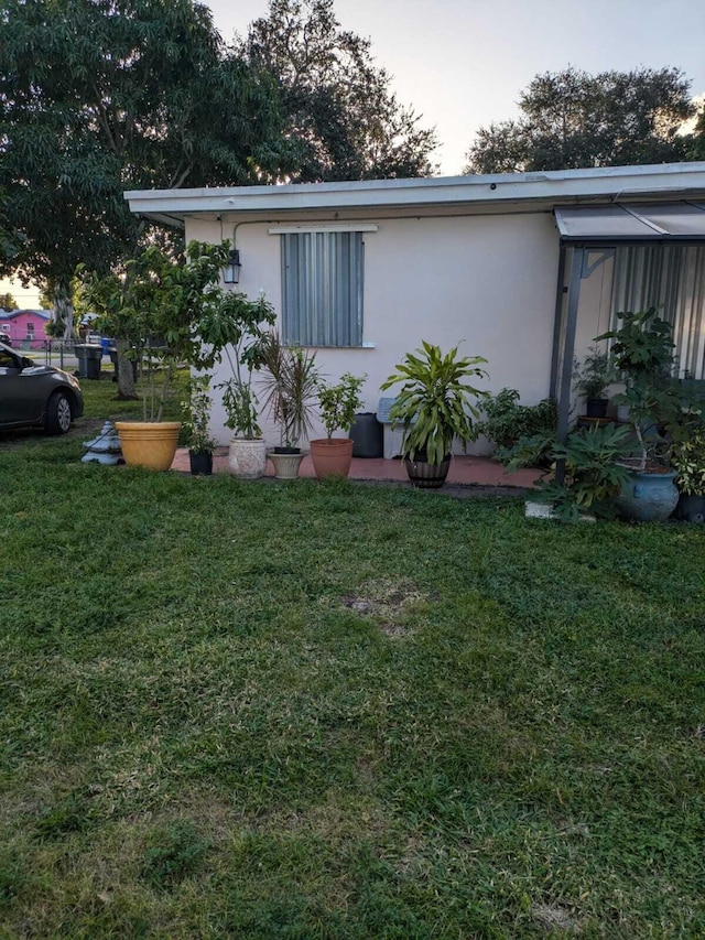 property exterior at dusk featuring a yard