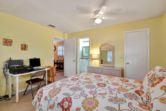 tiled bedroom with multiple windows, ensuite bathroom, ceiling fan, and a textured ceiling