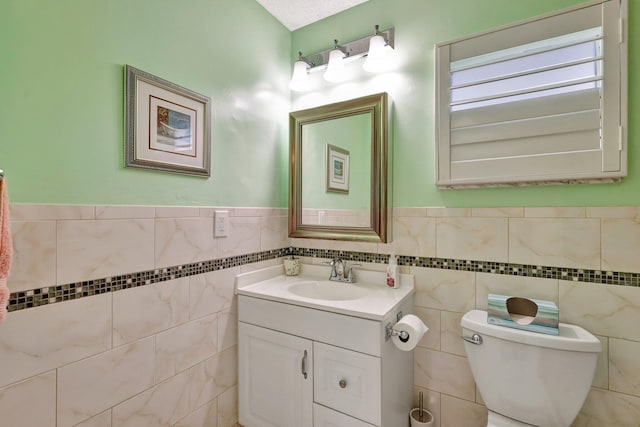 bathroom featuring vanity, toilet, and tile walls