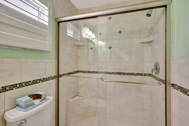 bathroom featuring toilet and an enclosed shower