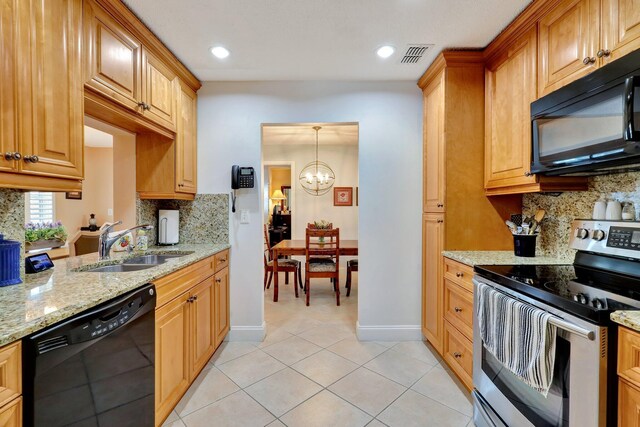 kitchen with black appliances, decorative backsplash, light stone counters, and a chandelier