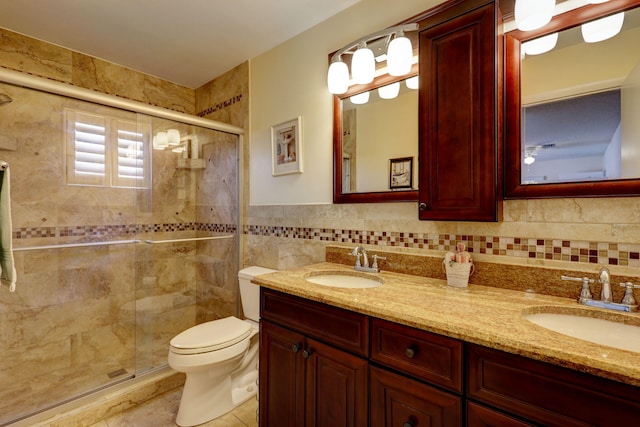 bathroom featuring vanity, tile patterned floors, toilet, walk in shower, and tile walls