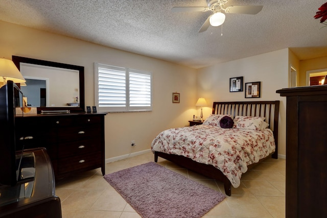 tiled bedroom featuring ceiling fan and a textured ceiling