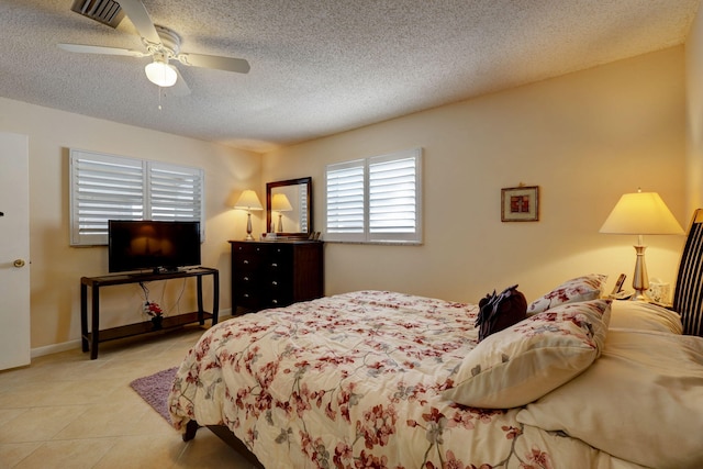 bedroom with ceiling fan and a textured ceiling