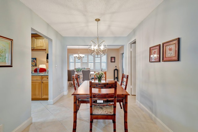 dining room with light tile patterned floors, a chandelier, and a textured ceiling