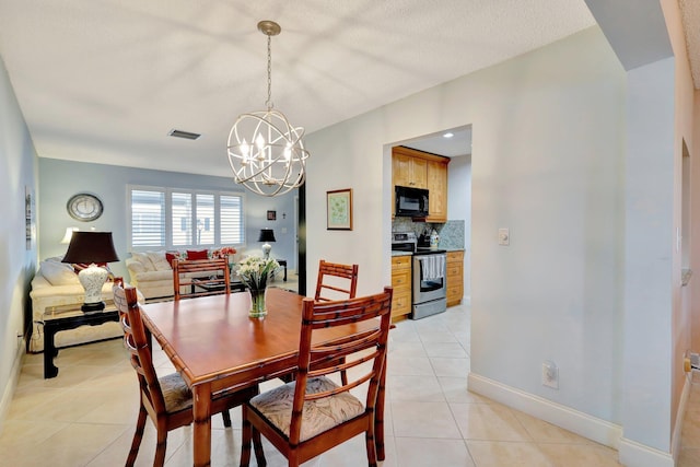 dining space featuring light tile patterned floors and a chandelier