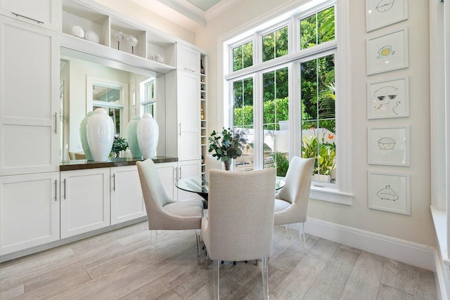 dining space featuring ornamental molding and light hardwood / wood-style floors