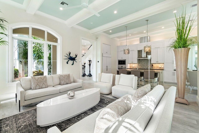 living room with light wood-type flooring, beamed ceiling, and crown molding