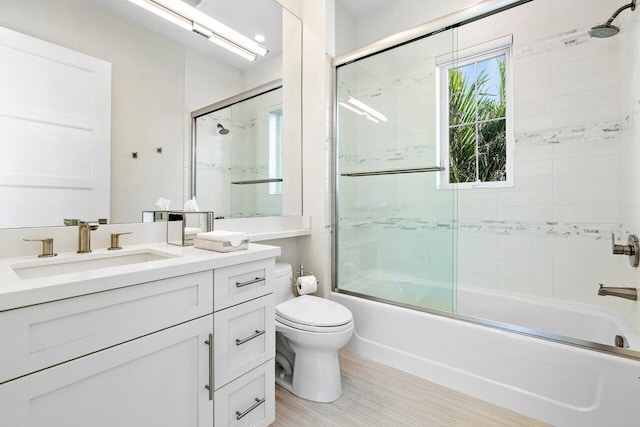 full bathroom with vanity, combined bath / shower with glass door, and toilet