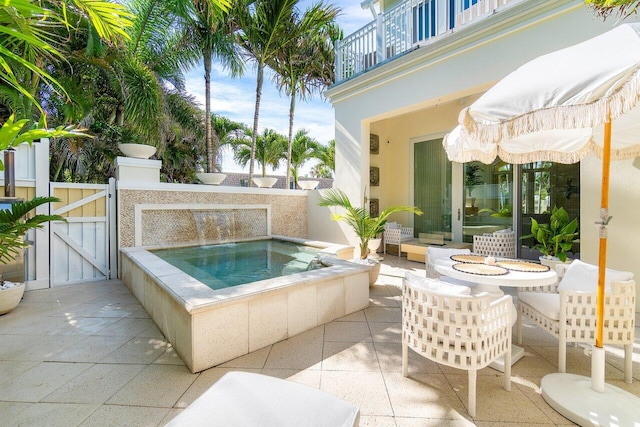 view of patio / terrace featuring a balcony and an in ground hot tub