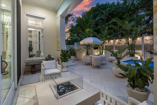 patio terrace at dusk with an outdoor living space with a fire pit