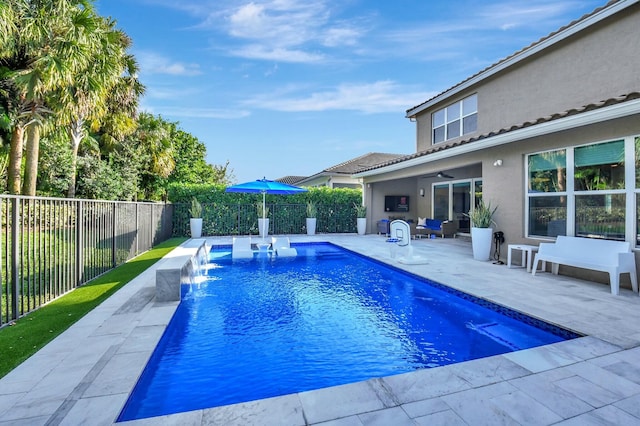 view of swimming pool with a patio area, pool water feature, and ceiling fan