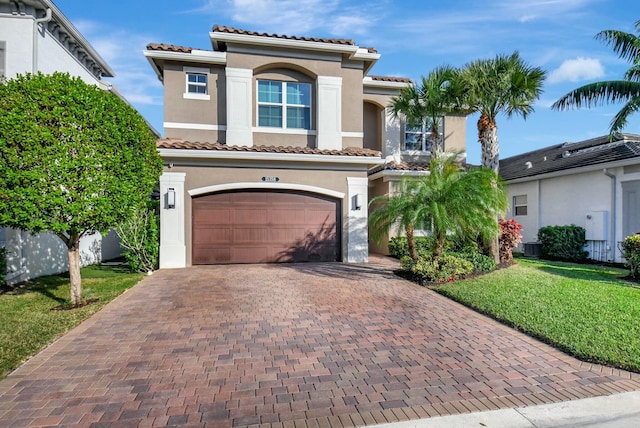 mediterranean / spanish-style house featuring a garage and a front yard