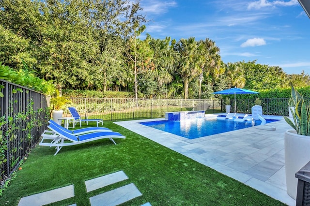 view of pool with pool water feature, a patio area, and a lawn