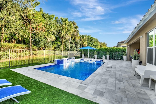 view of swimming pool featuring pool water feature, a patio, and a lawn