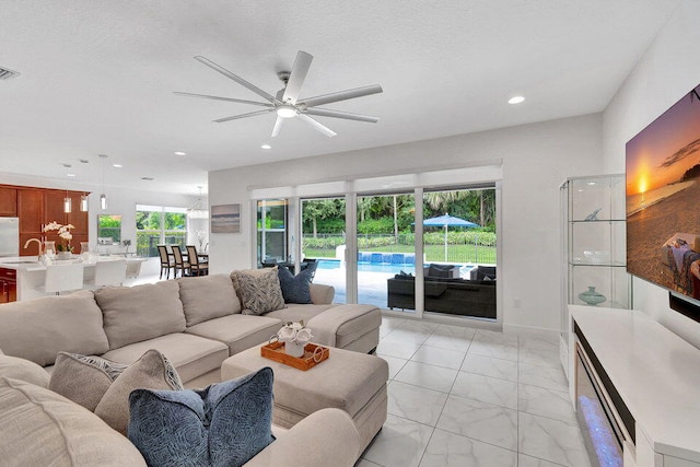 living room with sink, plenty of natural light, and ceiling fan