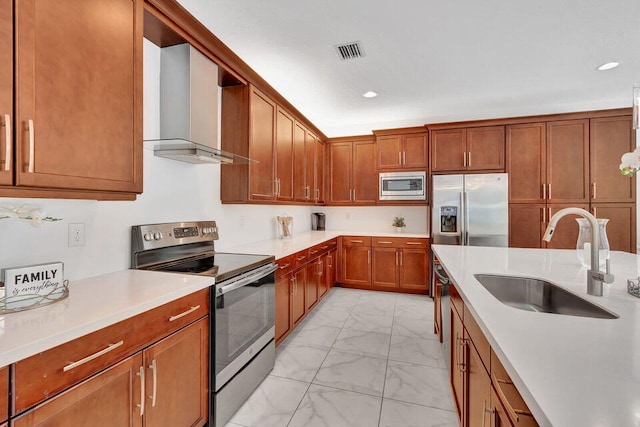 kitchen with stainless steel appliances, wall chimney exhaust hood, and sink