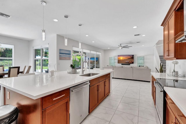 kitchen with appliances with stainless steel finishes, ceiling fan, sink, pendant lighting, and a center island with sink