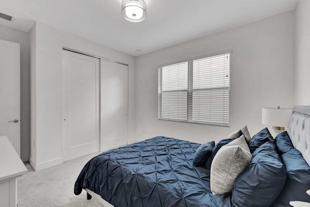 bedroom with a closet and light colored carpet