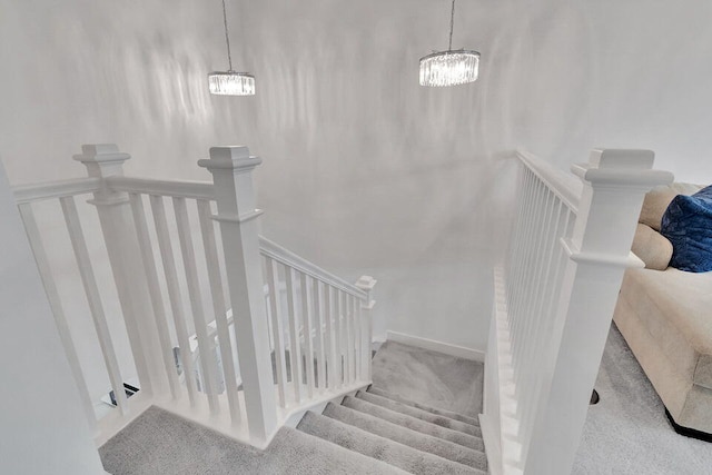 staircase with carpet and a notable chandelier