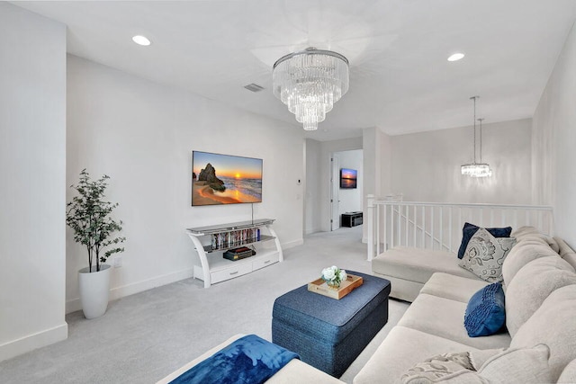 carpeted living room with an inviting chandelier