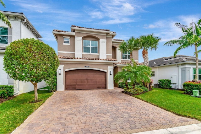 mediterranean / spanish-style house featuring a front yard and a garage