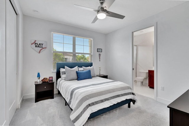 carpeted bedroom with ensuite bath and ceiling fan