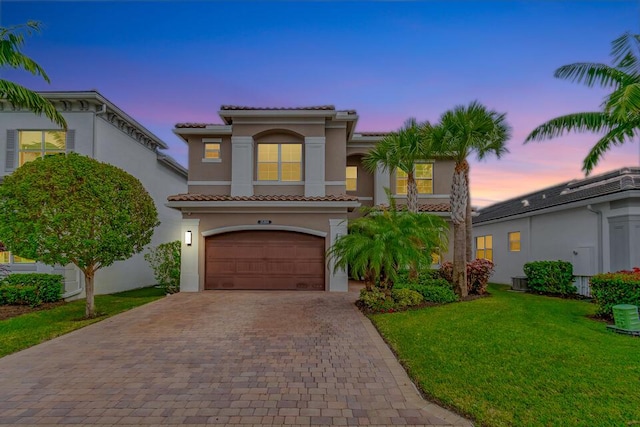 mediterranean / spanish-style home featuring a yard and a garage