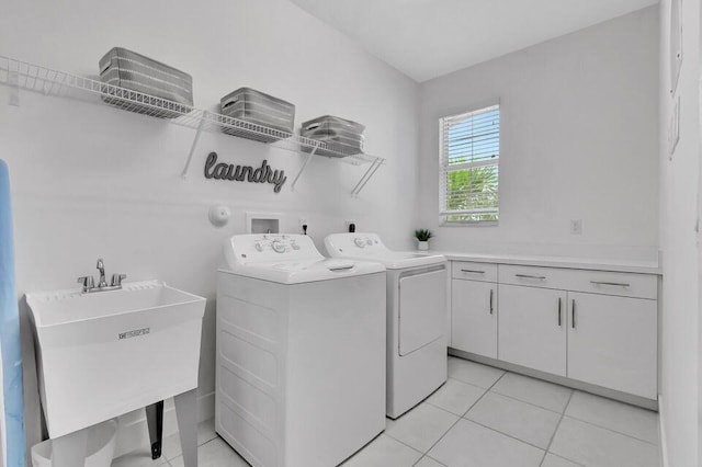 washroom featuring washing machine and dryer, sink, light tile patterned floors, and cabinets