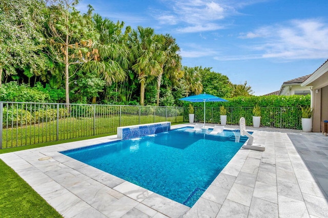 view of pool with a patio area, pool water feature, and a yard