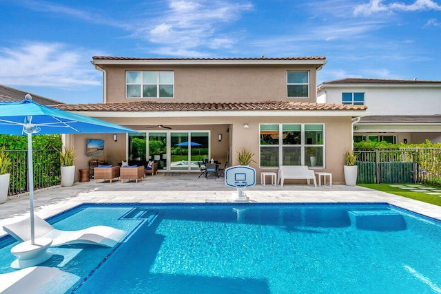 back of house featuring a patio, a fenced in pool, and ceiling fan