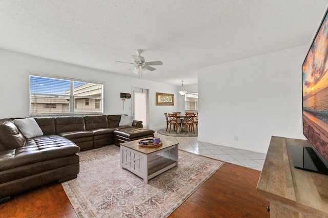 tiled living room featuring a textured ceiling and ceiling fan