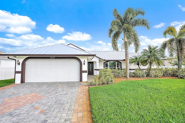 view of front of property with a garage and a front lawn