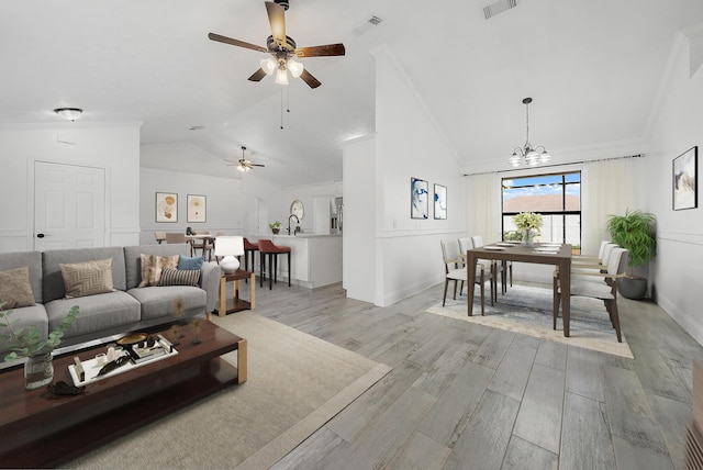 kitchen featuring lofted ceiling, a kitchen island with sink, light hardwood / wood-style flooring, a textured ceiling, and stainless steel appliances