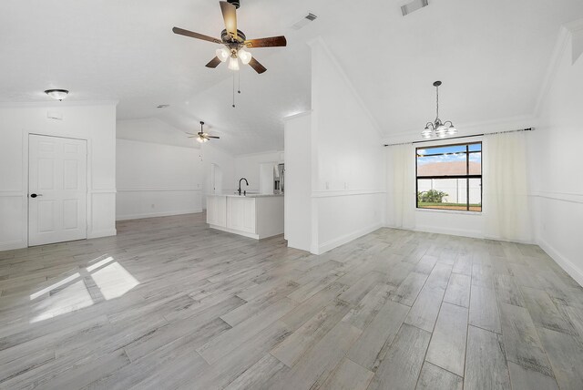 kitchen with white cabinetry, sink, stainless steel appliances, an island with sink, and lofted ceiling