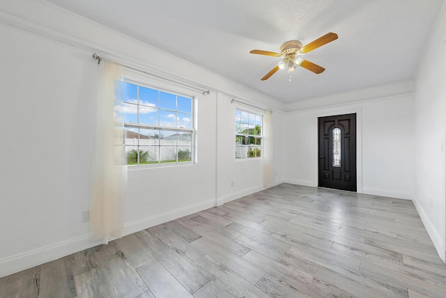 spare room with a textured ceiling, light wood-type flooring, ceiling fan, and crown molding