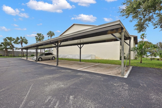 view of vehicle parking with a yard and a carport