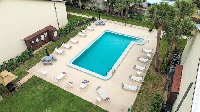 view of swimming pool with a patio area, a lawn, and ac unit