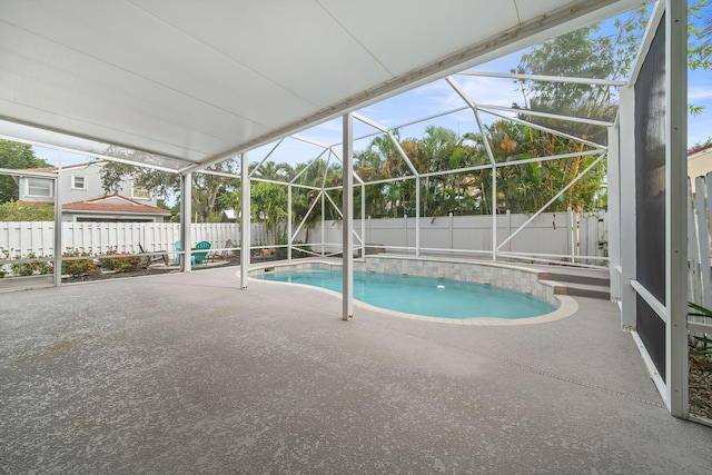 view of swimming pool featuring glass enclosure and a patio area