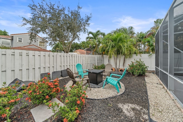 view of yard featuring a patio, an outdoor fire pit, and a lanai