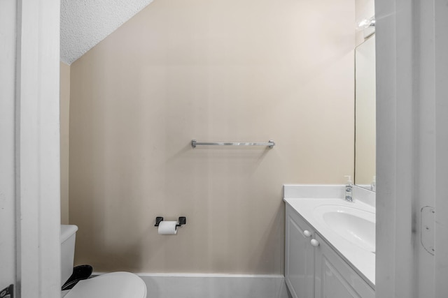 bathroom with vanity, a textured ceiling, and toilet