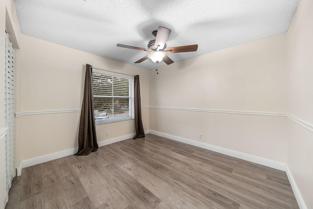 unfurnished room with light hardwood / wood-style floors, ceiling fan, and a textured ceiling