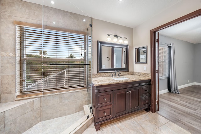 bathroom with wood-type flooring, a textured ceiling, vanity, and a shower